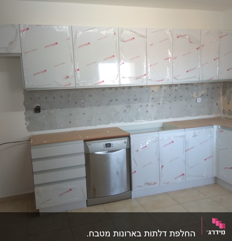 מטבח חדש עם ארונות מכוסים בניילון